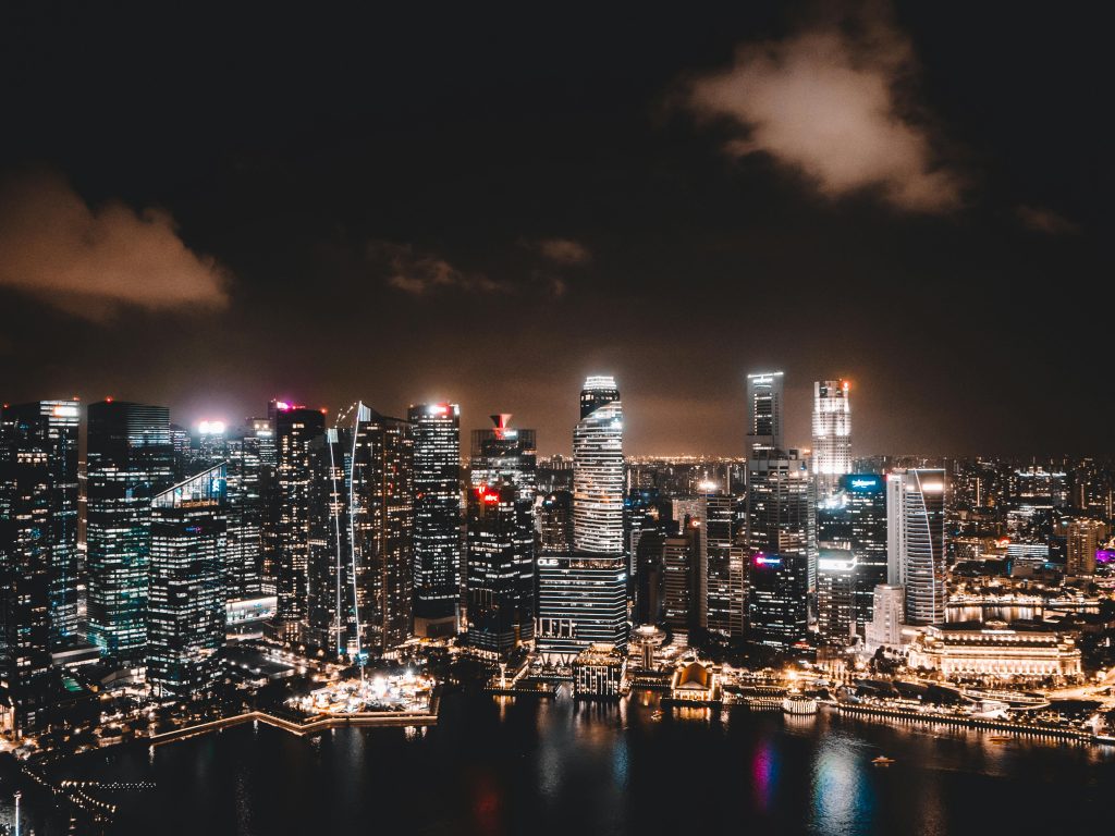 A breathtaking aerial view of Singapore's illuminated skyline at night, showcasing modern architecture and vibrant city life.